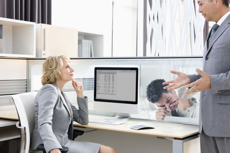 Businessman explaining to manager in office --- Image by © Ocean/Corbis