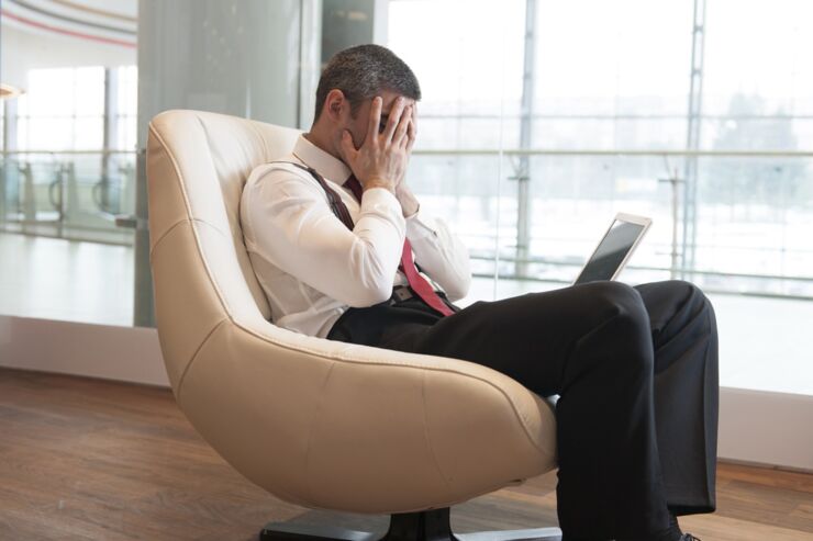 Stressed out businessman covers face with hands