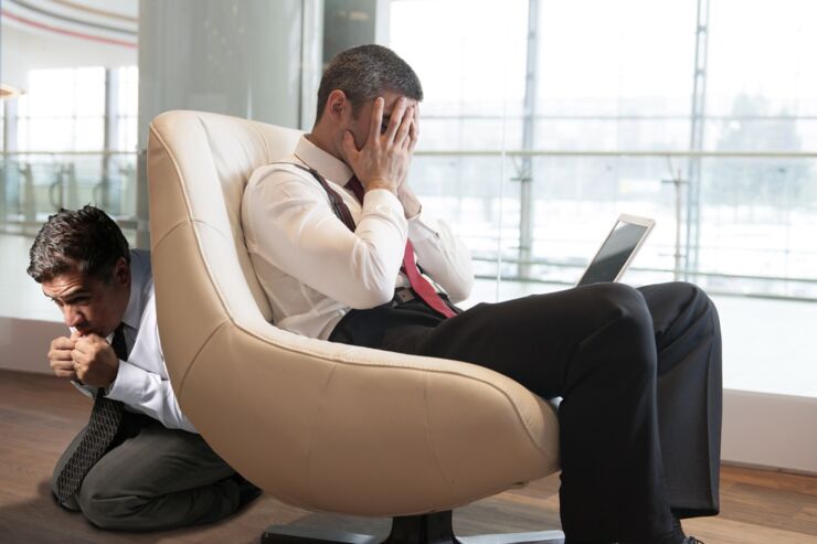 Stressed out businessman covers face with hands